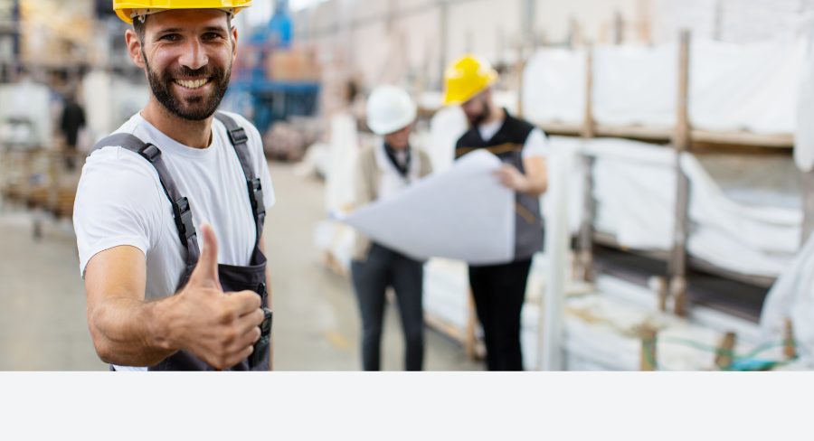 Mosolygó gyári munkás hüvelykujját felemelve, jelezve a biztonságos és balesetmentes munkakörnyezetet.